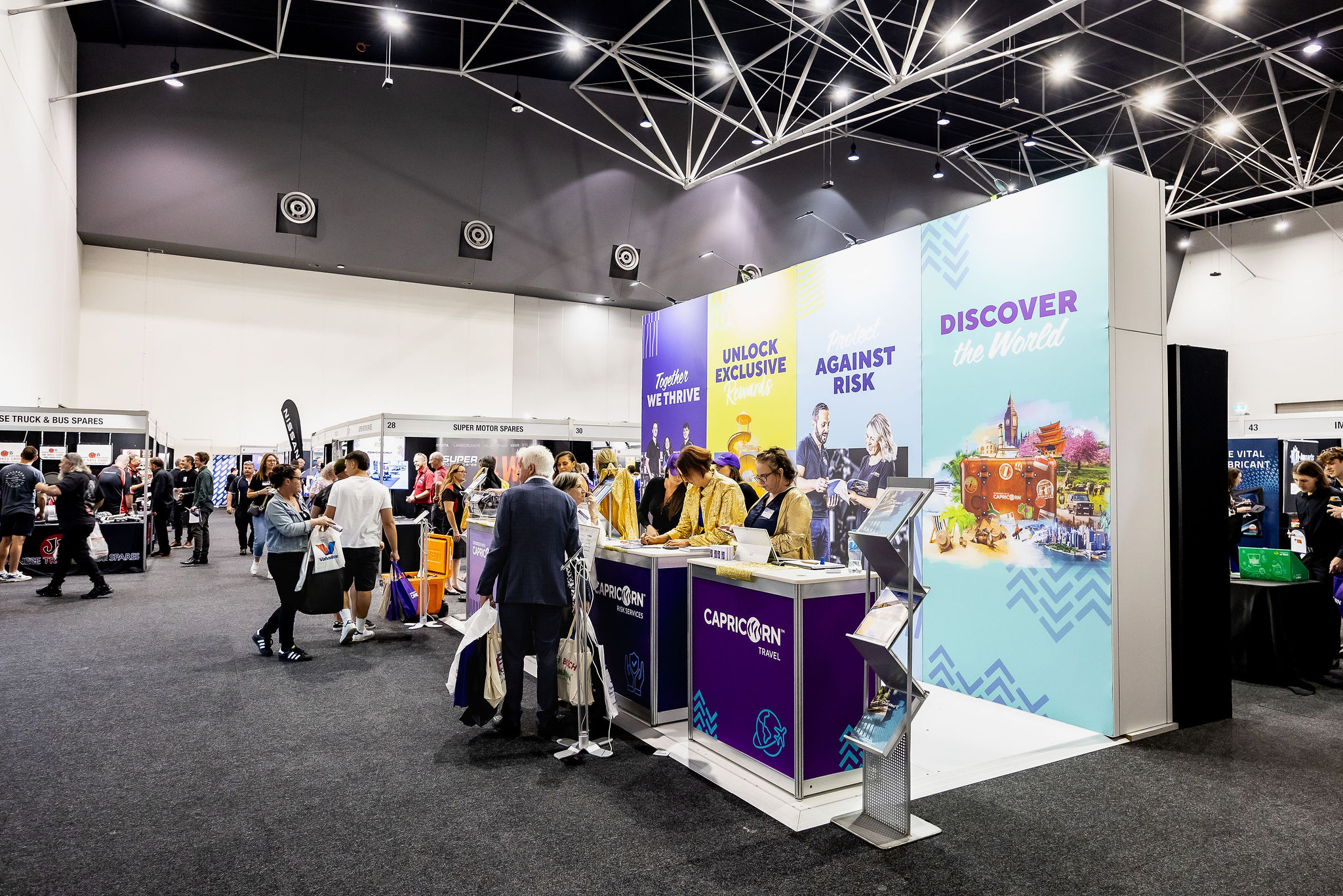 Attendees gather in a spacious exhibit hall at the Capricorn Trade Show, engaging with displays and each other.