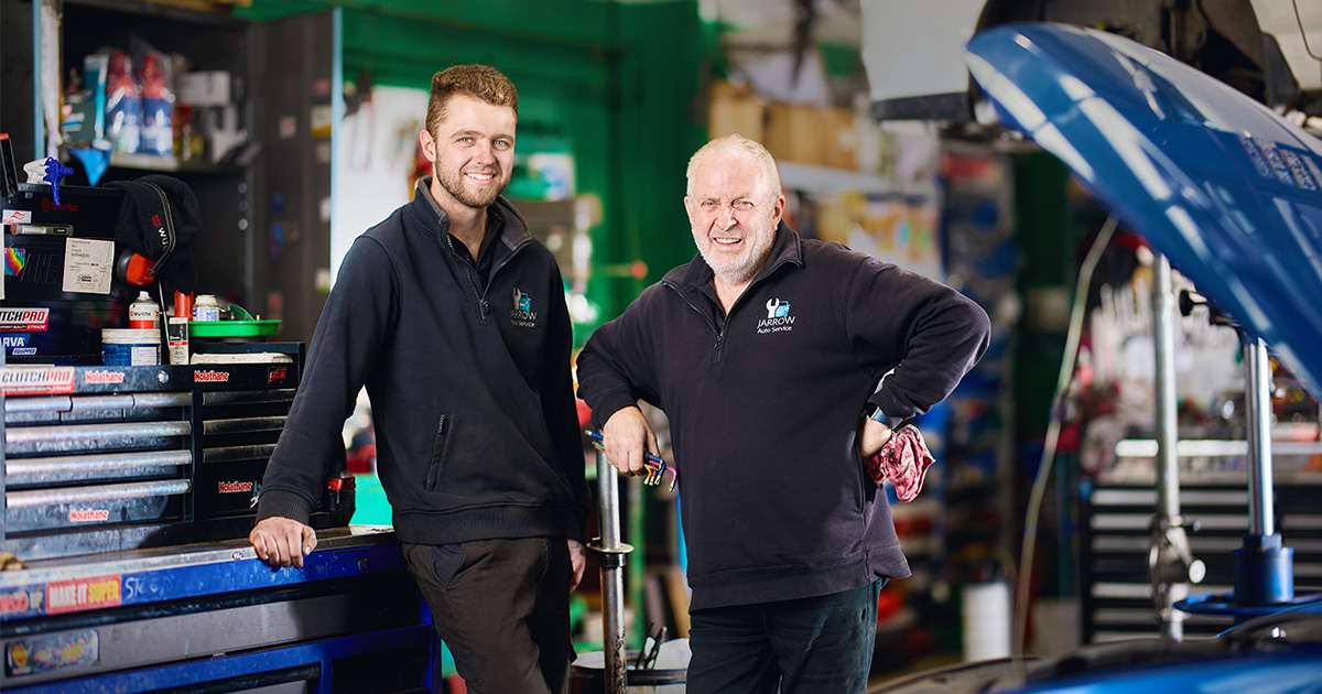 Capricorn Member, Stephen Rowe from Jarrow Auto Service and an employee, smiling in the workshop.